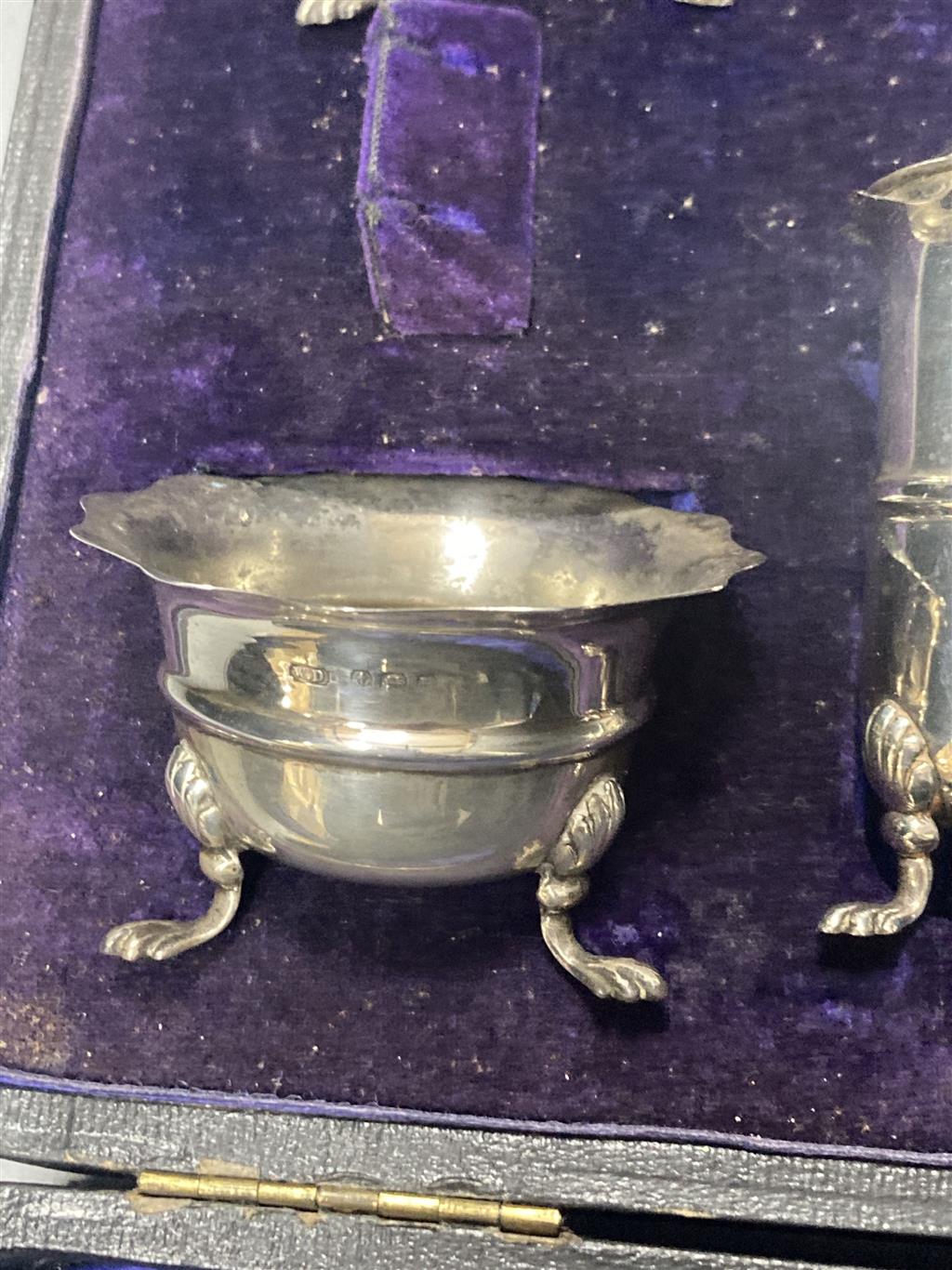 An Edwardian cased seven piece silver condiment set, Birmingham, 1907, (lacking spoons).